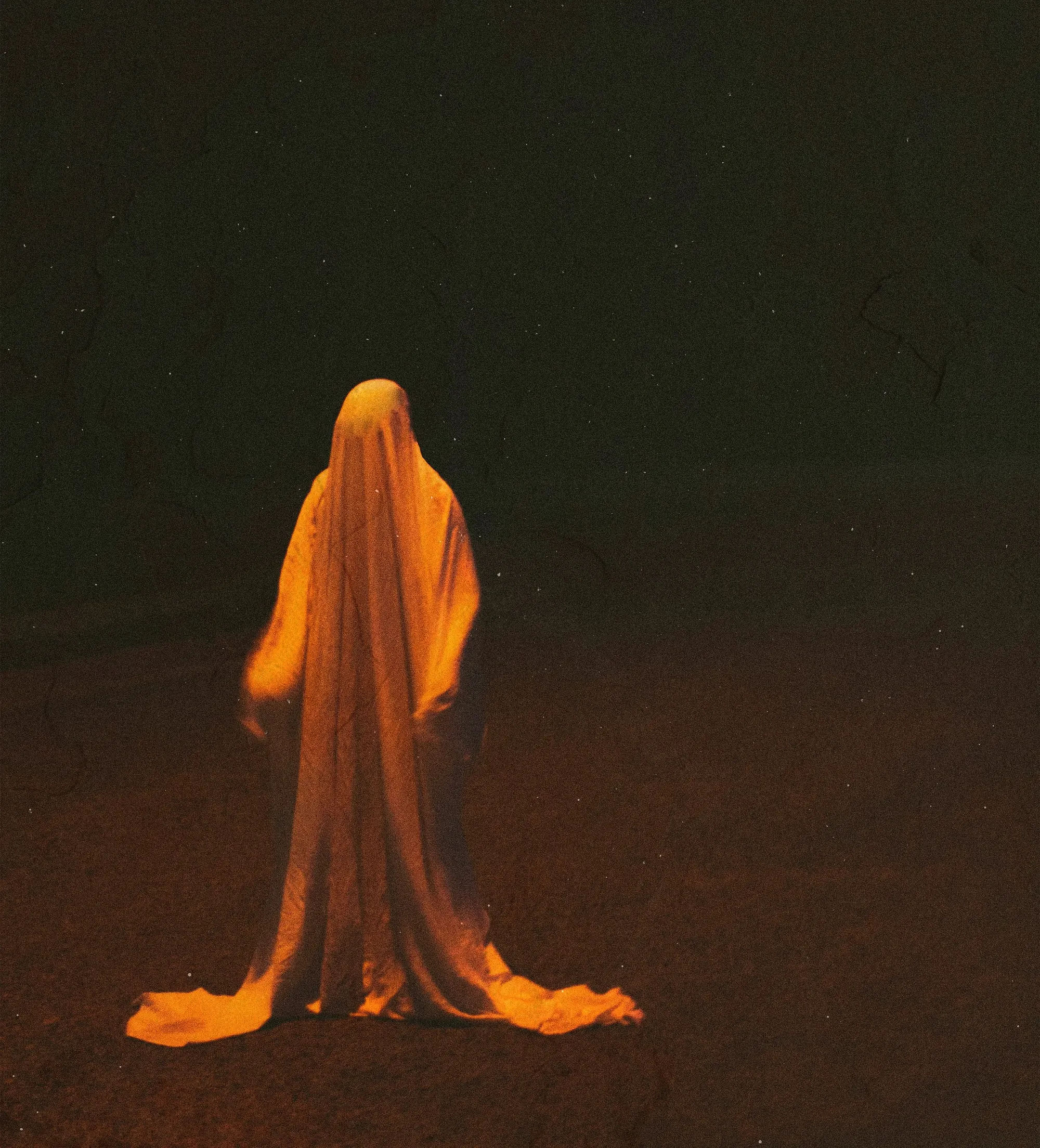person draped in white cloth in the night under red light